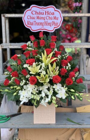 Giỏ hoa hồng đỏ, ly vàng và hoa lan trắng